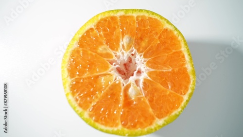 A luscious half orange shimmers  its juicy segments bursting with vitality. The close-up captures the intricate  inviting texture  exuding the fruit s refreshing appeal. Orange background.  