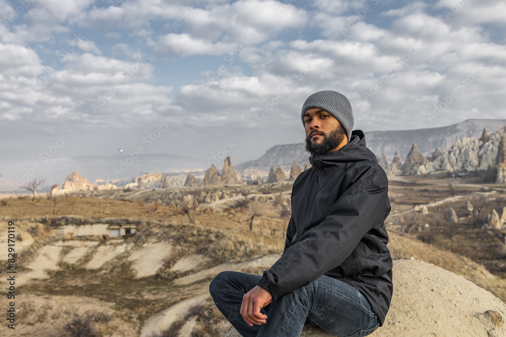 man hiking with blue sky and rock formation in the city of Cappadocia in Türkiye.