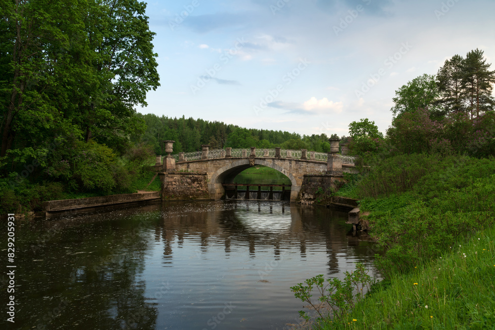 View of the Slavyanka River and the Viscontiev Bridge in the Pavlovsk Palace and Park Complex on a sunny summer day, Pavlovsk, Saint Petersburg, Russia