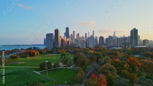 A drone reveal shot of the beautiful Chicago skyline with a view of Lake Michigan and Lincoln Park, filmed at sunset. photo