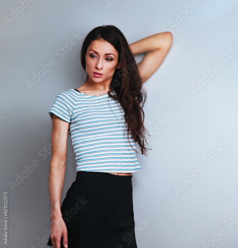 Serious business dissatisfied woman looking down waiting activity. Studio portrait on blue studio background on empty copy space. Closeup