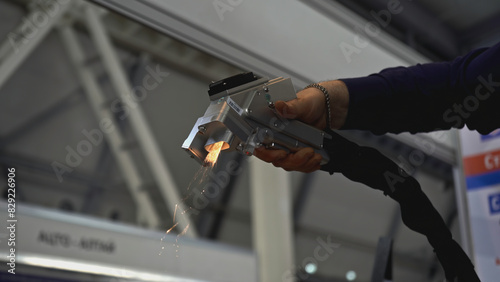 Laser removes rust on metal. Media. Hand gun with laser removes rust on metal. Laser with beam removes metal rust on parts