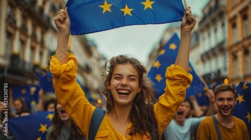 a joyful young woman holding up the European flag, surrounded by a festive crowd celebrating in the street. The backdrop shows cheerful and smiling people, capturing the spirit of unity and happiness photo