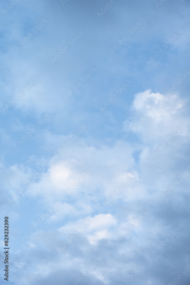 Clean blue and white sky nature background, medium blue sky with painterly white and blue clouds

