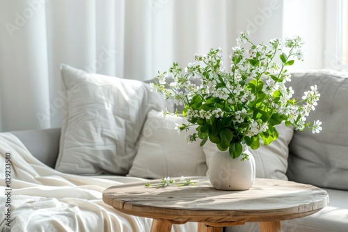 Flowers on table and grey settee in white living room with copy space Photo