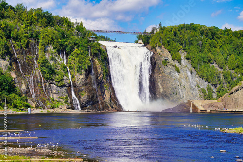 Magnificent view of the Montmorency Falls and the suspension bridge on a bright summer day with blue skies near Quebec city, the capital of Quebec province,Canada