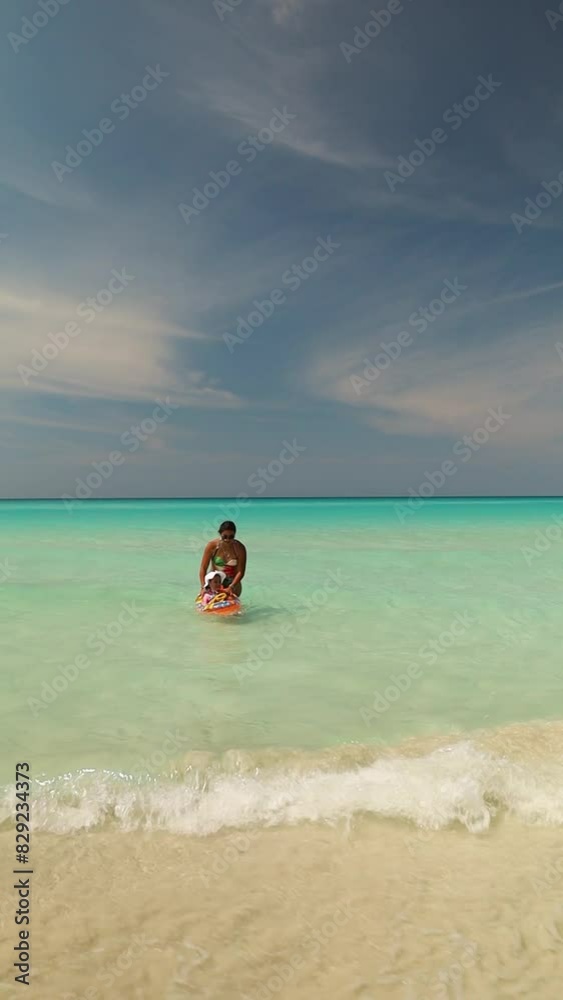 Happy Mexican mother playing with her 2-year-old daughter on the beautiful beaches of Varadero, Cuba. Happy Mexican mother playing with her 2-year-old daughter on the beautiful beaches of Varadero, Cuba.