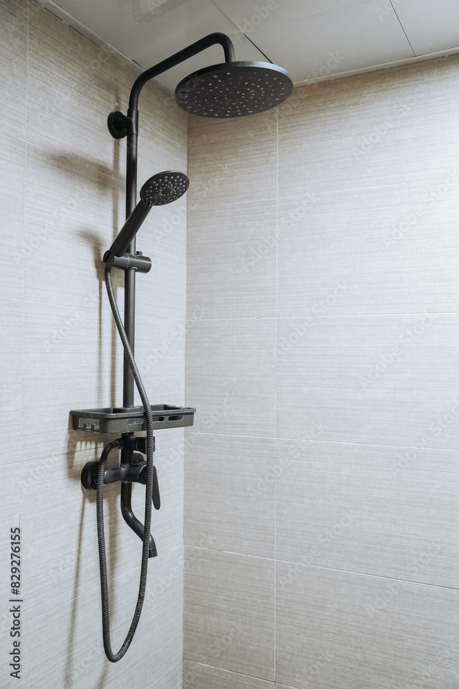 Modern shower zone with rain head, hand held shower. Beige tiles in the bathroom