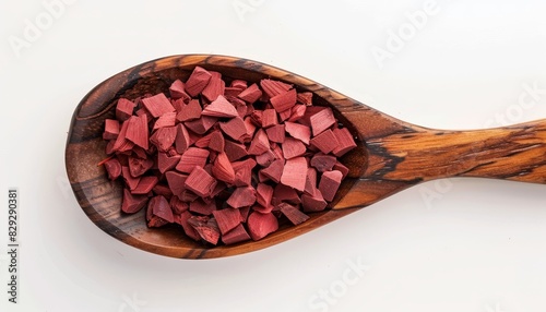 Top view of red Sandalwood incense chips on white background presented in a wooden spoon Also known as Sanderswood rubywood or red saunders photo