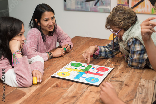 Multi-generational family playing board games at home