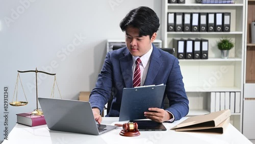 Asian man lawyer working and gavel, tablet, laptop. justice and law concept.