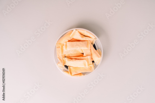 Open plastic jar with sachets of non-smoking tobacco product with fruity flavor on a light background.
