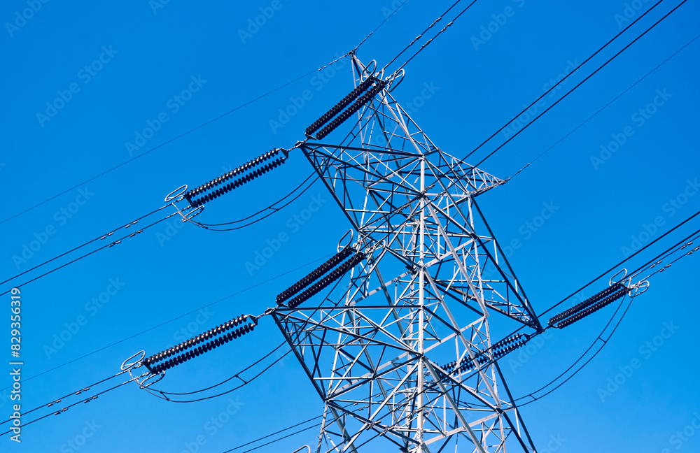 Low angle view of electricity transmission tower with overhead wires in Baghmundi, Purulia, West Bengal. Part of electricity grid, it carries high voltage electricity through long distance rural areas Low angle view of electricity transmission tower with overhead wires in Baghmundi, Purulia, West Bengal. Part of electricity grid, it carries high voltage electricity through long distance rural areas