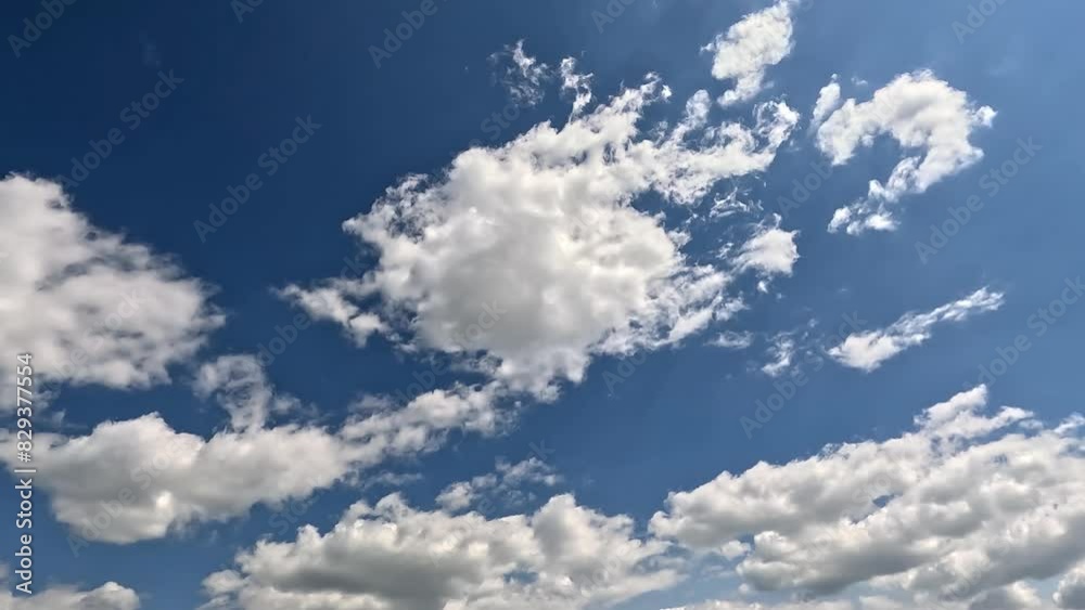Wonderful endless clouds in the blue skies. 4K video (Ultra High Definition) of cloudscape and bright sun. Sky and clouds Timelapse. Sun shines through the clouds on the blue sky background.