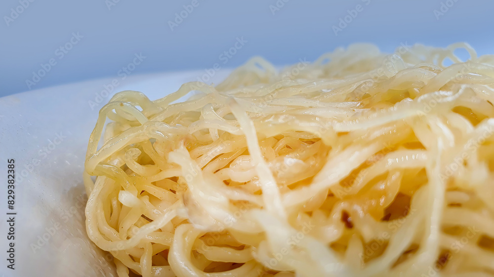 Cooked egg noodles boiled and mixed with fried garlic oil in a bowl, Asian style food, ready to eat, isolated in plain background, local food business Cooked egg noodles boiled and mixed with fried garlic oil in a bowl, Asian style food, ready to eat, isolated in plain background, local food business