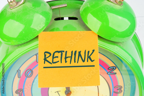 Rethink is shown using a text the inscription on the sticker on top of the alarm clock photo