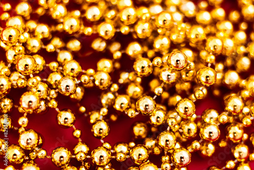 Background from golden beads on a red background. The atmosphere of Christmas and New Year. Christmas background