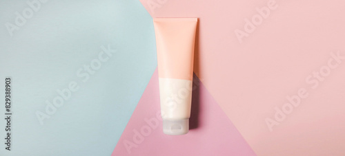 A clean label facial or body cream tube is isolated on a multi-color background. Beauty product mockup. Wellness packaging. Banner for Branding