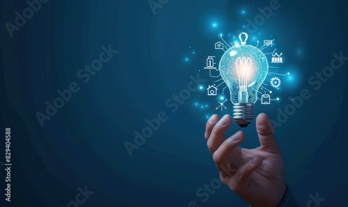 Light bulb with innovation icons in businessman’s hand. Concept of business creativity and solutions.