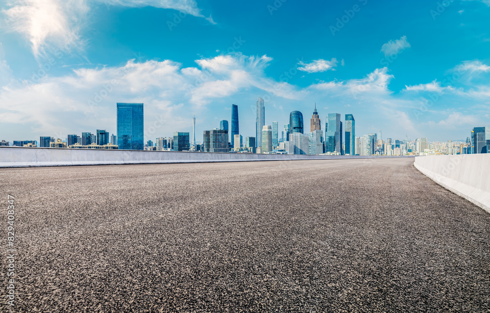 Empty asphalt road and modern city skyline background