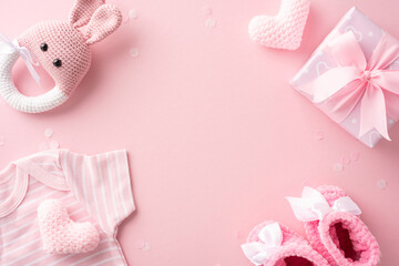 Flat lay of baby girl shower gifts including clothes, toys, and presents on a pink background. Perfect for celebrating a new arrival