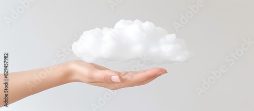 A hand grasping a cloud set against a white backdrop with ample copy space photo