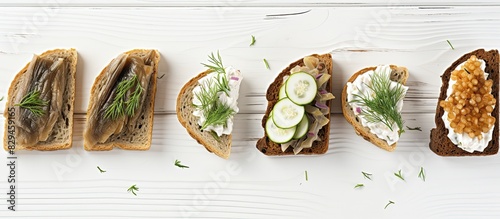 Healthy north traditional sandwiches of dry crisps wheat bread with sprats fish cream cheese green onion on soft light white wood background closeup copy space photo