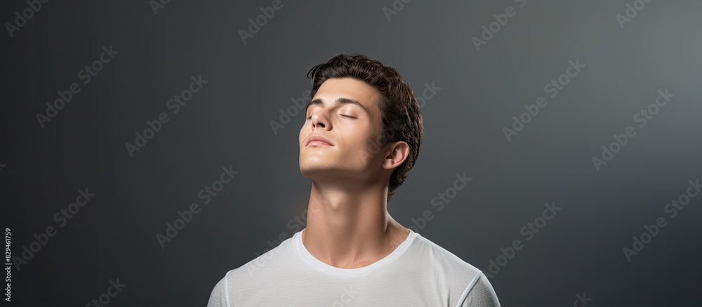 Obraz premium Studio portrait of a thoughtful young man in a white t shirt He presses his lips together hard and looks up Isolated large image on grey background. copy space available