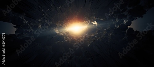 An isolated round hole in black paper with torn edges and piercing sunlight and rays through it Sunlight breaking through the darkness from a hole. copy space available