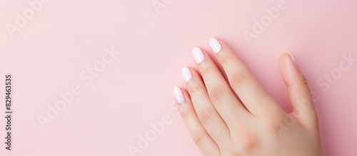 High resolution widescreen image featuring a pink background adorned with the elegant beauty of female fingers showcasing a beautiful manicure Ample copy space available