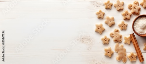 A composition featuring a copy space image with cookie cutters a whisker and a rolling pin on a white textured wooden surface as seen from above photo