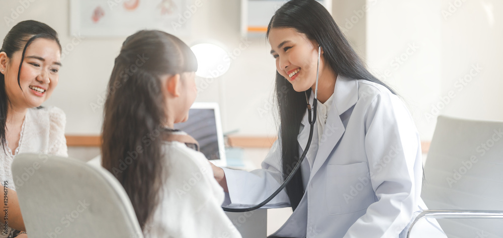 Fototapeta premium Southeast asian Paediatrician doctor woman using stethoscope check little girl health care in kid clinic examining room