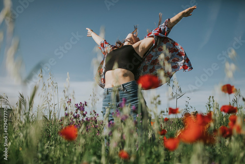 Carefree woman with arms outstretched in meadow photo