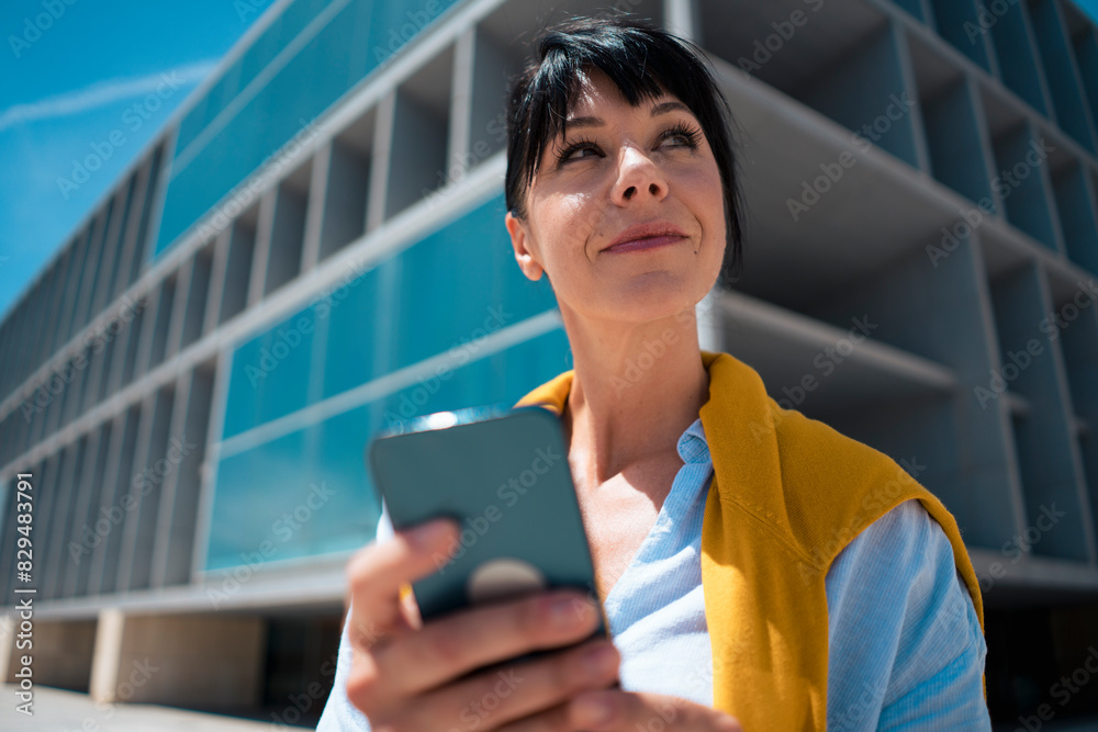 Thoughtful businesswoman holding smart phone Thoughtful businesswoman holding smart phone