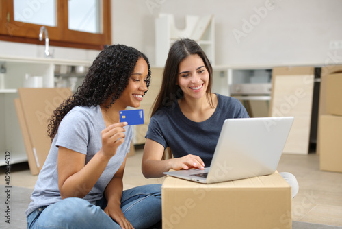 Happy roommates moving home and buying online photo