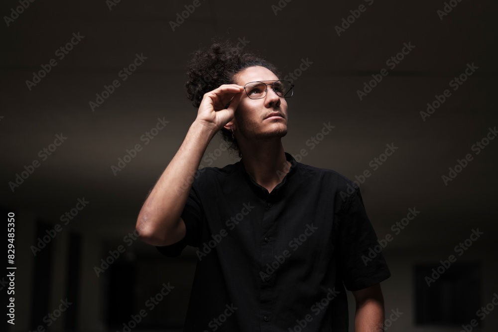 Thoughtful young man holding eyeglasses Thoughtful young man holding eyeglasses