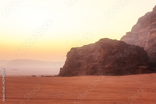 Wadi Rum, Jordan. Orange sand desert landscape and rock mountains at dawn, tents camp