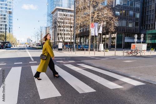 Fashionable businesswoman crossing street in city photo