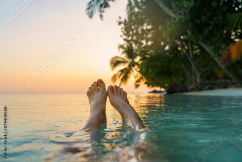 Woman?s legs in sea at sunset photo