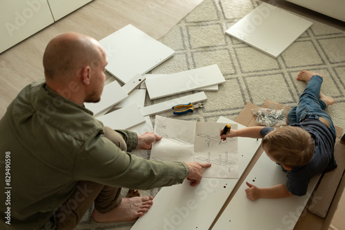 Father showing instruction manual to son at home photo