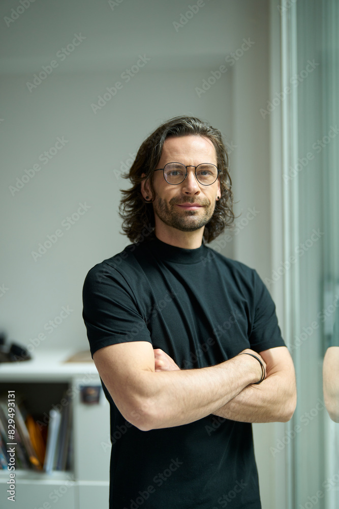 Confident businessman standing with arms crossed at office Confident businessman standing with arms crossed at office