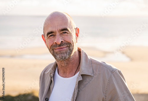 Smiling mature man with stubble at beach photo