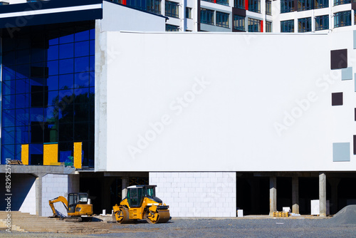 advertisement wall empty copy space template in modern building construction area architecture exterior yard environment with equipment, material and transport sidewalk rink bulldozer