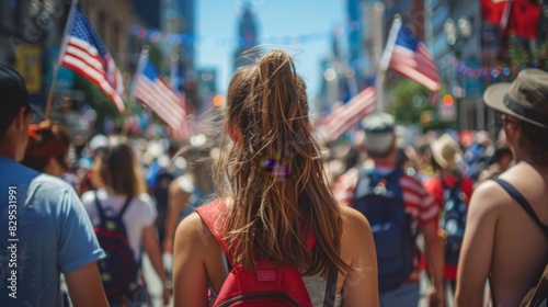 a young girl smiling at the camera while holding the American flag, during a United States Independence Day celebration. Taken from behind the crowd © nicole