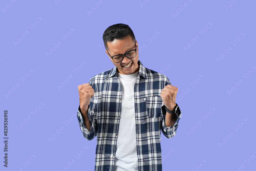 portrait of a young handsome Asian man making a success gestures isolated in a purple background portrait of a young handsome Asian man making a success gestures isolated in a purple background
