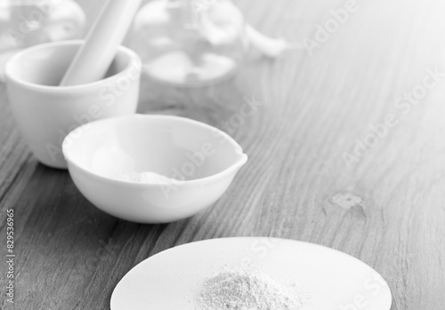 Mortar pestle and white powder on the wooden table.