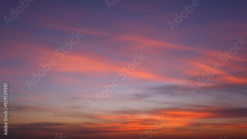 A vibrant sunset with the sky painted in stunning shades of pink, orange, and purple. Wispy clouds streak across the sky, enhancing the beauty of the scene, creating a tranquil and mesmerizing view.  © Punyawee