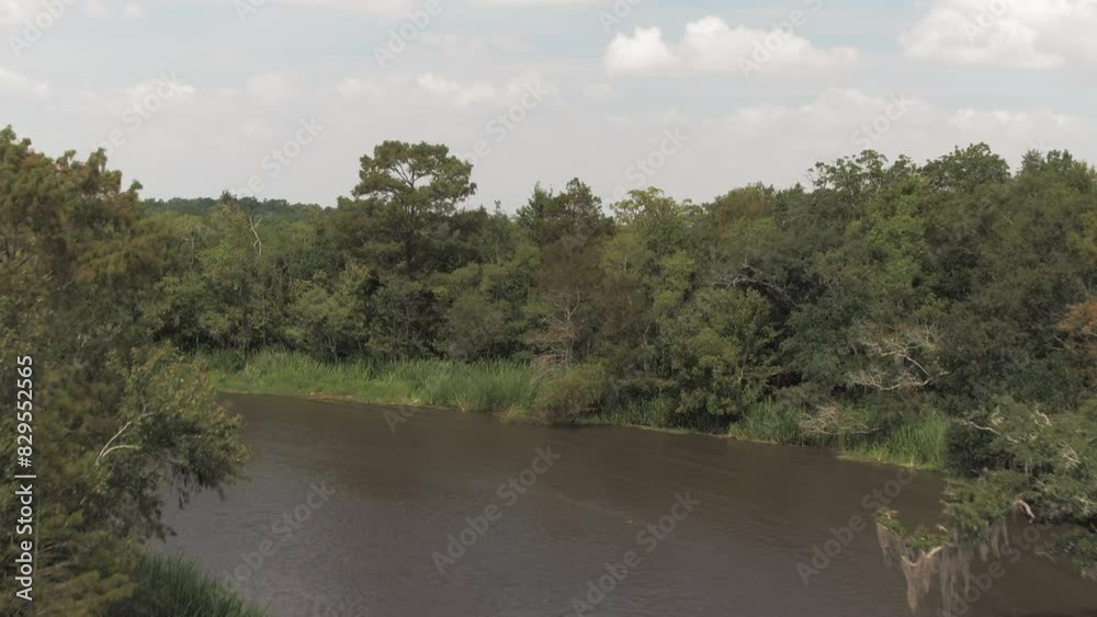Aerial Forward Ascending Shot Of Rippled River Stream In Green Forest Against Cloudy Sky - Bayou Vista, Texas Aerial Forward Ascending Shot Of Rippled River Stream In Green Forest Against Cloudy Sky - Bayou Vista, Texas