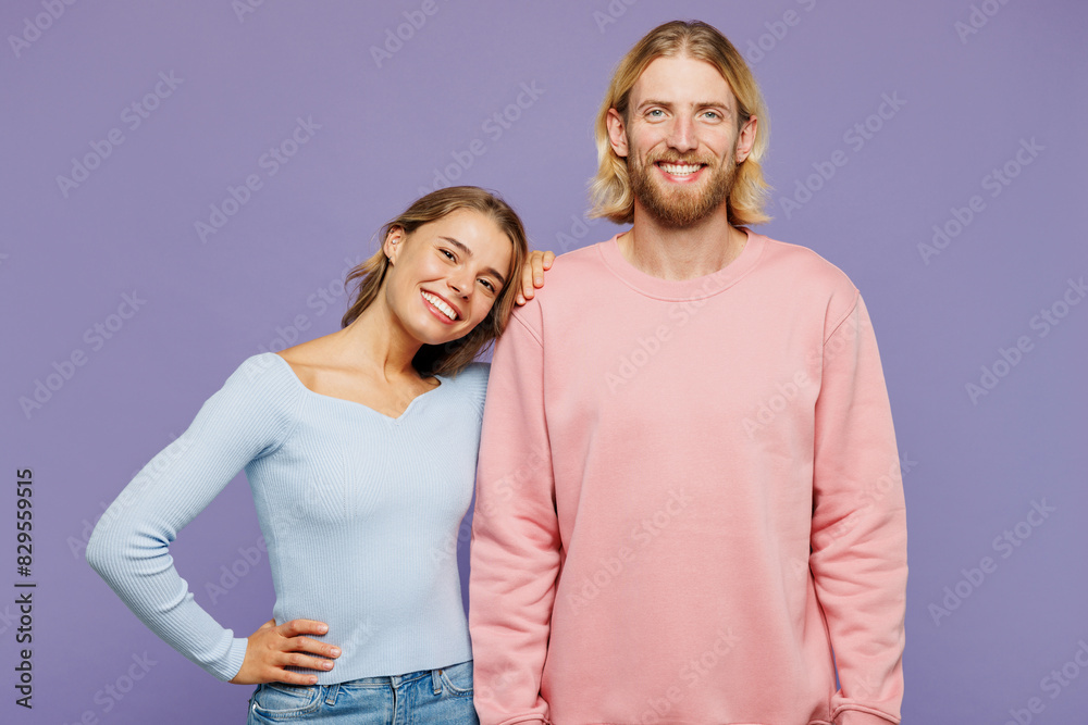 Young smiling couple two friends family man woman wear pink blue casual clothes together girl put head on boy shoulder hug look camera isolated on pastel plain light purple background studio portrait. Young smiling couple two friends family man woman wear pink blue casual clothes together girl put head on boy shoulder hug look camera isolated on pastel plain light purple background studio portrait.