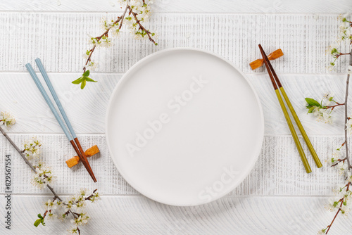 Table adorned with cherry blossom branch and chopsticks, epitomizing Japanese food culture